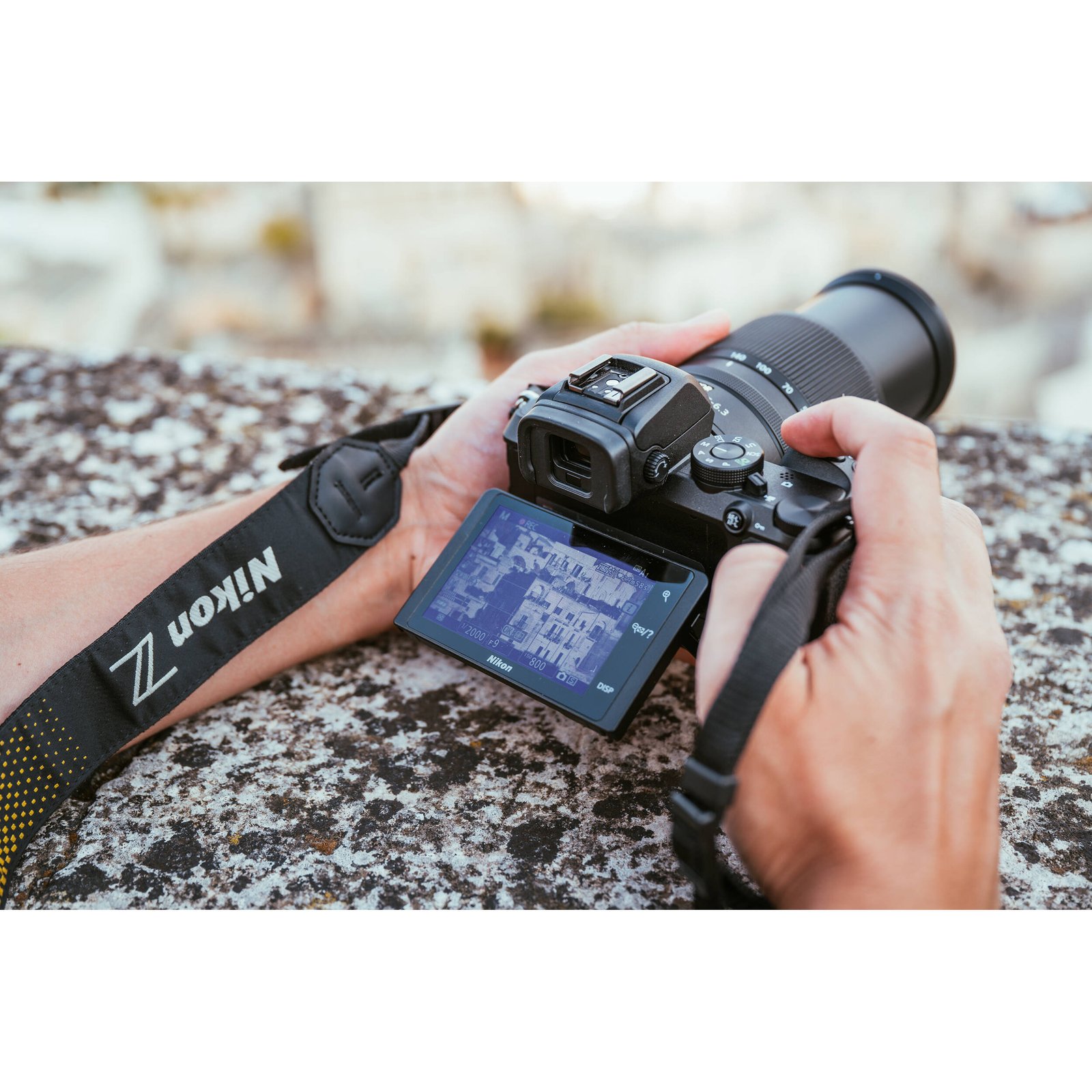 Nikon Z50 II with 18-140mm lens held in hand showing its grip and size